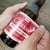 3.75" x 3" weatherproof white matte label being wrapped around beer bottle