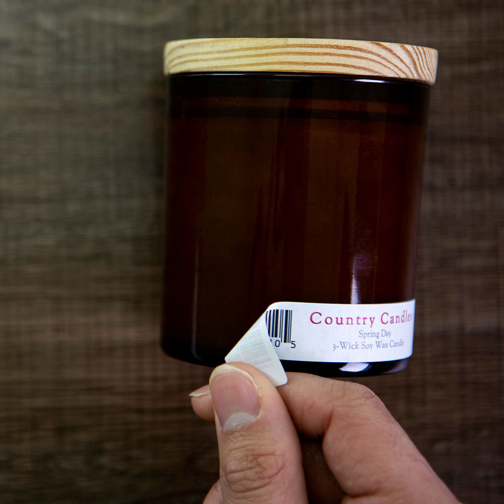 3.4375" x 0.669" rectangular label in removable white matte being removed from candle jar