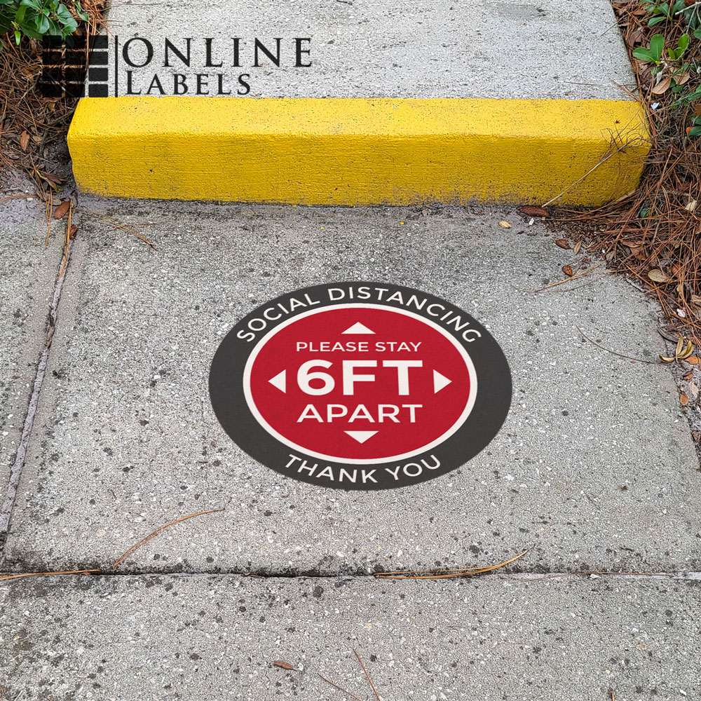 Social distancing floor sticker promoting 6-feet spacing in lines; placed on concrete outdoors