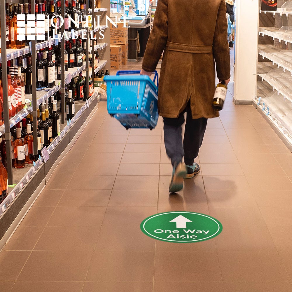 Green "one way aisle" wayfinding floor sign in store