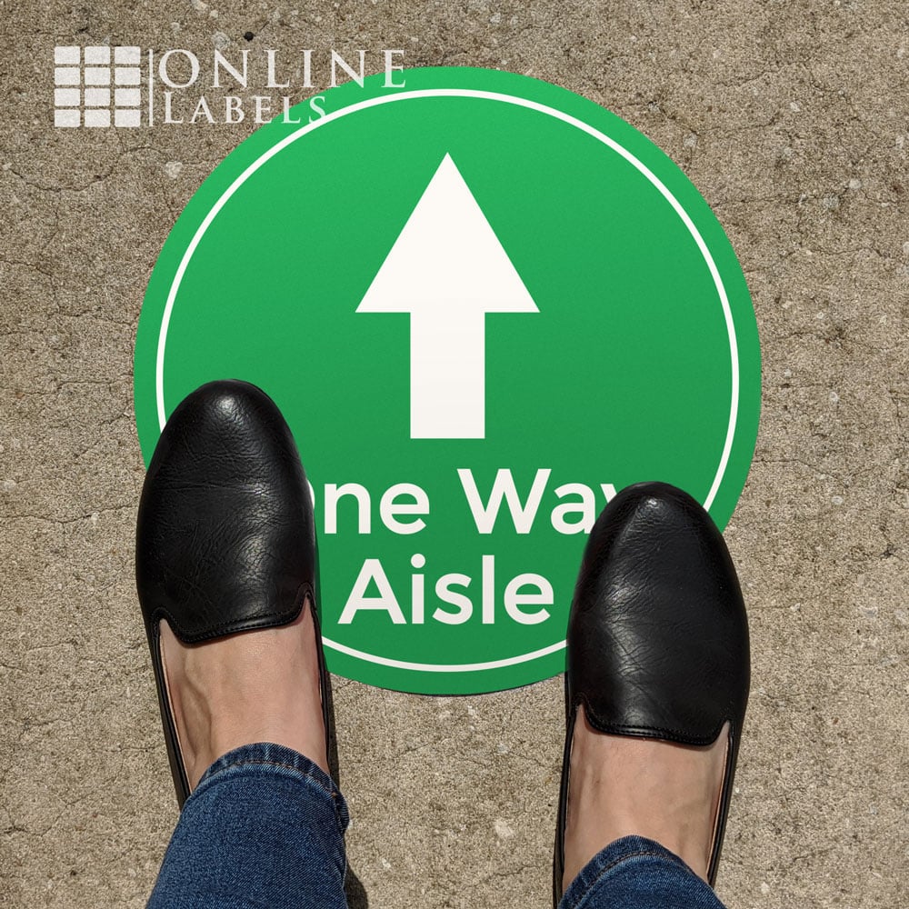 Feet on "one way aisle" green floor sign (covid safety)