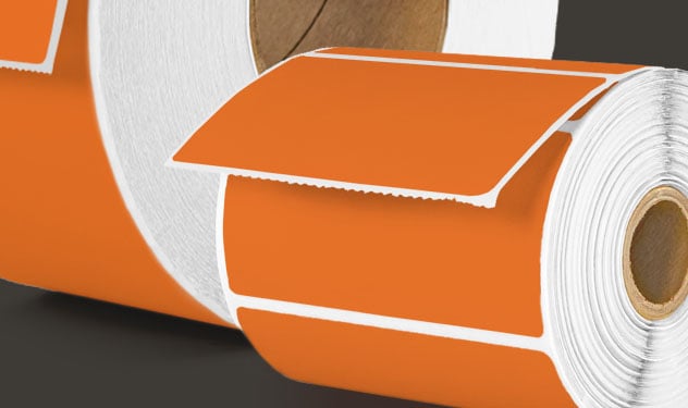 Orange direct thermal labels on rolls.